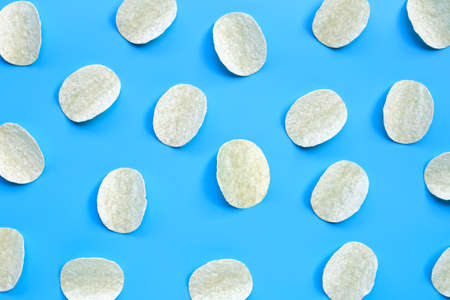 Potato chips on blue background. Top viewの写真素材