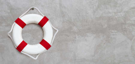 Lifebuoy on concrete wall background. Copy space