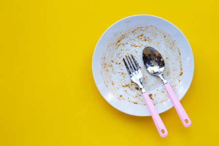 Dirty dish on yellow background. Top viewの写真素材