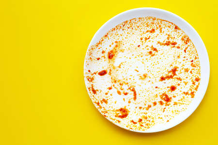 Dirty dish on yellow background. Copy spaceの写真素材