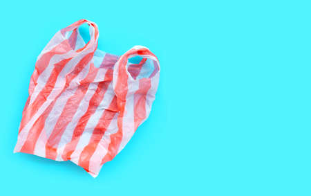 Colorful plastic bag on blue background. Copy space