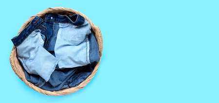 Jeans in laundry basket on blue background. Top viewの写真素材
