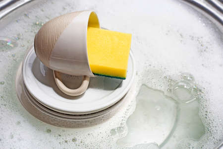Dish washing, Dirty dishes with cup soaking in kitchen sink.の写真素材