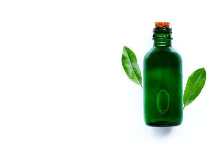 Essential oil bottle with green leaves on white background. Copy spaceの写真素材