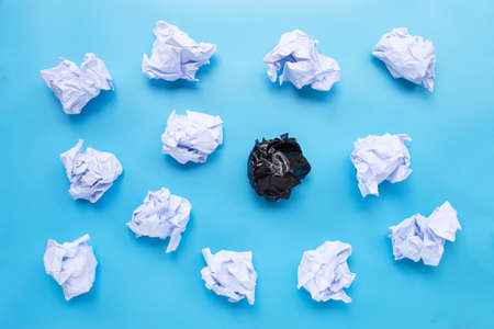 White and black crumpled paper balls on a blue background. Top viewの写真素材