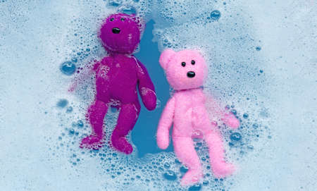 Soak toy teddy bear in laundry detergent water dissolution before washing.  Laundry concept, Top...