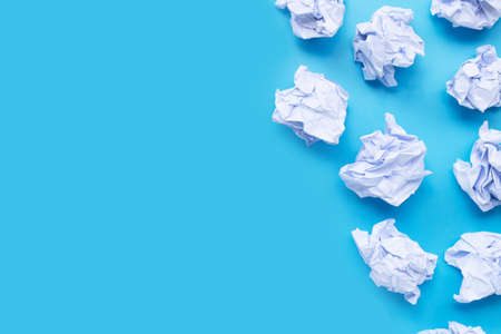 White crumpled paper balls on a blue background. Top view