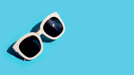 Sunglasses on blue background. Enjoy holiday concept. Copy spaceの写真素材