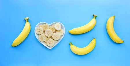 Ripe yellow bananas on blue background. Top viewの写真素材