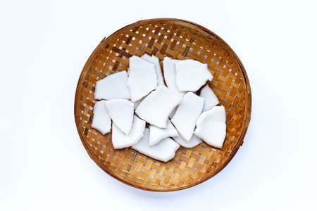 Coconut pieces on wooden bamboo threshing basket on white background.の写真素材