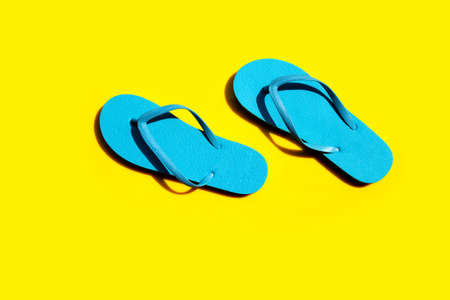 Blue flip flops on yellow background. Top viewの写真素材