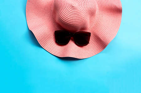 Sunglasses with summer hat on blue background. Enjoy holiday concept. Copy spaceの写真素材