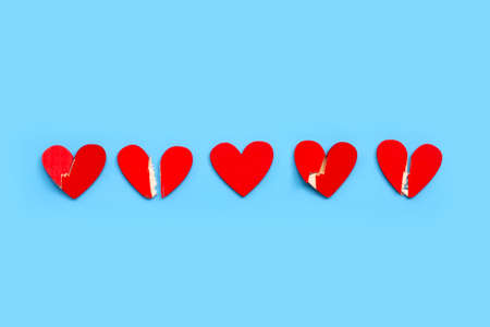 Broken wooden heart on blue background. Copy space