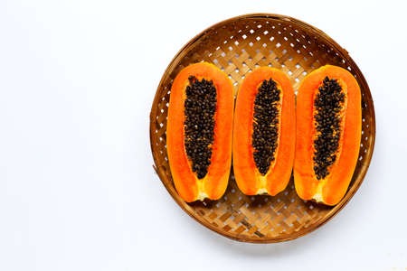 Ripe papaya fruit in wooden bamboo threshing basket on white background. Copy spaceの写真素材