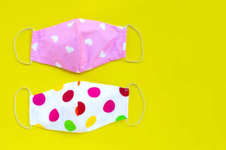Handmade colorful cloth masks on yellow background. Copy space