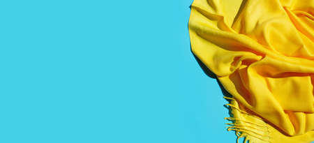 Yellow scarf summer on blue background. Top view with copy space