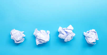 White crumpled paper ball on blue background. Copy spaceの写真素材