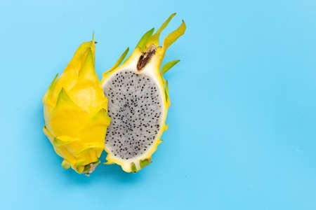 Yellow pitahaya or dragon fruit on blue background. Copy spaceの写真素材