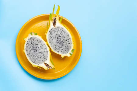 Yellow pitahaya or dragon fruit on yellow plate on blue background. Copy spaceの写真素材