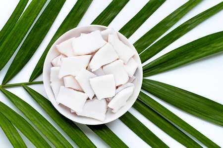 Coconut pieces on dish plate on tropical palm leaves. Top viewの写真素材