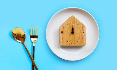 Golden spoon and fork on blue background.  Copy spaceの写真素材