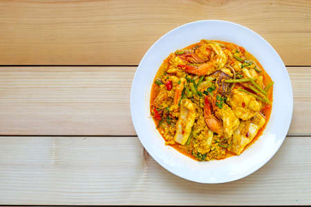 Fried seafood with curry powder on wooden background. Top viewの写真素材