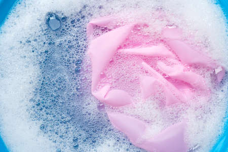 Color clothes soak in powder detergent water dissolution. Laundry conceptの写真素材