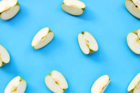 Green apple slices on blue background. Top view