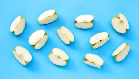 Green apple slices on blue background. Top viewの写真素材