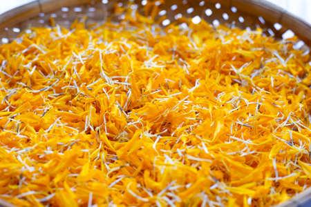 Petals of marigold flower in bamboo basketの写真素材