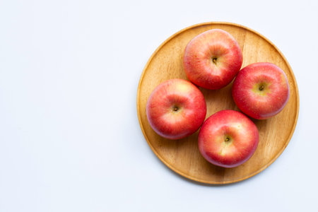 Juicy apples on wooden plate on white background.の写真素材