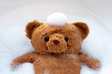 Soak toy bear in laundry detergent water dissolution before washing.  Laundry concept, Top viewの写真素材