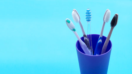 Toothbrushes in plastic glass on blueの写真素材