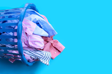 Clothes with a laundry basket on blueの写真素材
