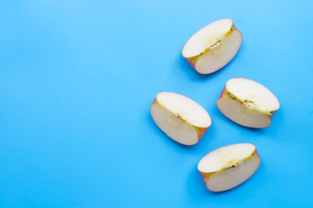 Ripe apple slices on blue background.の写真素材