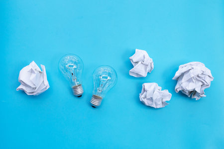 Light bulb with white crumpled paper on blue background. Ideas and creative thinking concept. Top viewの写真素材