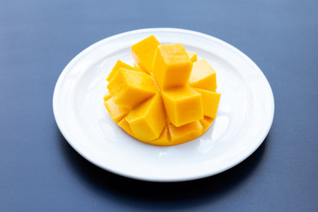 Tropical fruit, Mango on white plate on dark background.の写真素材