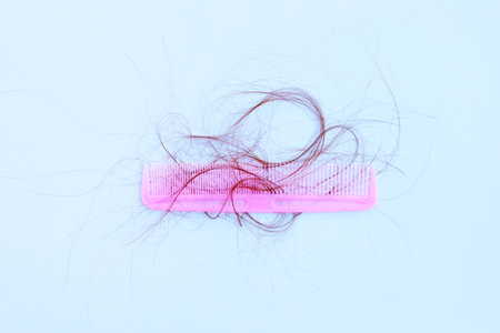 Hairs loss fall in comb on white background.