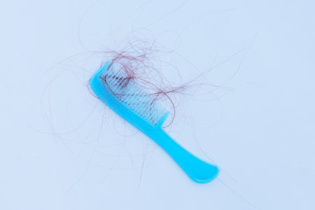 Hairs loss fall in comb on white background.の写真素材