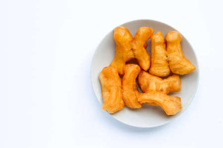 Deep-fried dough stick, chinese bread stick in white dish on white background with copy spaceの写真素材