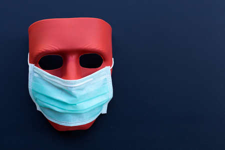 Red mask wear protective face mask on dark background.の写真素材