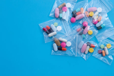 Colorful tablets with capsules and pills in medicine bags on blue background. Top viewの写真素材