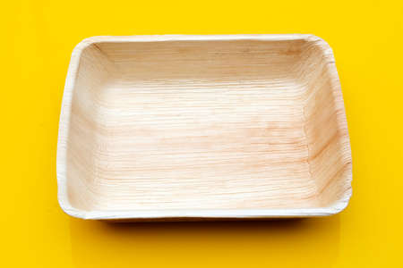 Betel palm leaf plate on yellow background.の写真素材