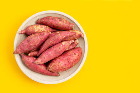 Sweet potato on yellow background. Top viewの写真素材