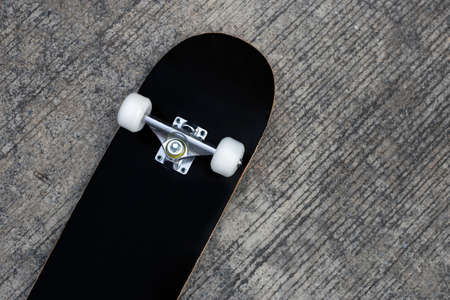 Black skateboard on cement ground.の写真素材