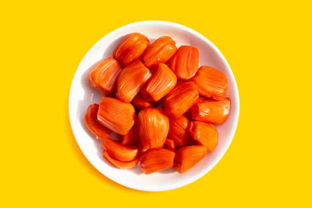 Ripe red Jackfruit in white plate on yellow background.の写真素材