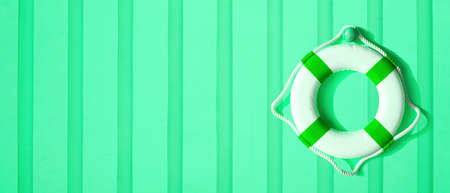 Lifebuoy on green wall background. Summer background concept