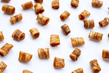 Dried banana rolled chips on white background.の写真素材