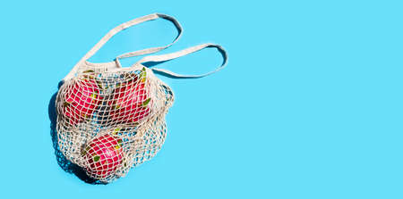 Dragon fruit inmesh beach bag on blue background.の写真素材