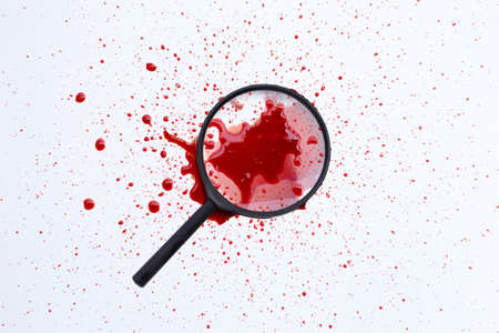Magnifying glass with blood on white background.の写真素材
